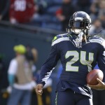 Seattle Seahawks running back Marshawn Lynch stands on the field during warmups before an NFL football game against the Arizona Cardinals, Sunday, Nov. 23, 2014, in Seattle. (AP Photo/Elaine Thompson)