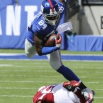 New York Giants tight end Larry Donnell (84) leaps over Arizona Cardinals' Tony Jefferson (22) during the first half of an NFL football game Sunday, Sept. 14, 2014, in East Rutherford, N.J. (AP Photo/Bill Kostroun)