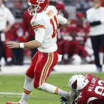 Kansas City Chiefs' Alex Smith (11) breaks a tackle by Arizona Cardinals' Dan Williams (92) as he runs with the ball during the first half of an NFL football game Sunday, Dec. 7, 2014, in Glendale, Ariz. The Cardinals defeated the Chiefs 17-14. (AP Photo/Ross D. Franklin)
