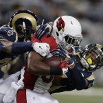 Arizona Cardinals running back Stepfan Taylor is tackled by St. Louis Rams' Trumaine Johnson, left, and Rodney McLeod during the first half of an NFL football game Thursday, Dec. 11, 2014 in St. Louis. (AP Photo/Darron Cummings)