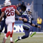 Seattle Seahawks quarterback Russell Wilson (3) slides after carrying the ball to a first down as Arizona Cardinals' Rashad Johnson moves in in the second half of an NFL football game, Sunday, Nov. 23, 2014, in Seattle. The Seahawks won 19-3. (AP Photo/Elaine Thompson)