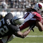 Arizona Cardinals wide receiver Larry Fitzgerald (11) falls forward as he is tackled by Oakland Raiders outside linebacker Khalil Mack (52) during the second quarter of an NFL football game in Oakland, Calif., Sunday, Oct. 19, 2014. (AP Photo/Marcio Jose Sanchez)