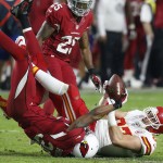 Arizona Cardinals' Deone Bucannon, left, strips the ball away from Kansas City Chiefs' Travis Kelce, right, as Cardinals' Jerraud Powers (25) looks on during the second half of an NFL football game Sunday, Dec. 7, 2014, in Glendale, Ariz. The Cardinals defeated the Chiefs 17-14. (AP Photo/Ross D. Franklin)