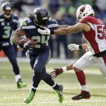 Seattle Seahawks running back Marshawn Lynch (24) runs as Arizona Cardinals middle linebacker Larry Foote, right, tries to tackle him in the first half of an NFL football game, Sunday, Nov. 23, 2014, in Seattle. (AP Photo/Stephen Brashear)