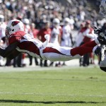 Arizona Cardinals wide receiver Jaron Brown catches a pass in front of Oakland Raiders cornerback T.J. Carrie (38) during the first quarter of an NFL football game in Oakland, Calif., Sunday, Oct. 19, 2014. (AP Photo/Ben Margot)