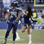 Seattle Seahawks' Marshawn Lynch (24) turns away after joining Seahawks' Sea Gals cheerleaders as they danced on the field during a break late in the second half of an NFL football game against the Arizona Cardinals, Sunday, Nov. 23, 2014, in Seattle. The Seahawks won 19-3. (AP Photo/Elaine Thompson)