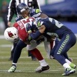Arizona Cardinals quarterback Drew Stanton (5) is sacked by Seattle Seahawks outside linebacker Bruce Irvin, top, and free safety Earl Thomas, right, in the second half of an NFL football game, Sunday, Nov. 23, 2014, in Seattle. (AP Photo/Stephen Brashear)