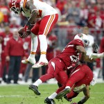 Kansas City Chiefs wide receiver Dwayne Bowe, left, leaps over Arizona Cardinals free safety Rashad Johnson, right, and Justin Bethel, center, during the first half of an NFL football game, Sunday, Dec. 7, 2014, in Glendale, Ariz. (AP Photo/Ross D. Franklin)