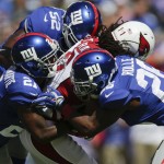 New York Giants cornerback Dominique Rodgers-Cromartie (21), Antrel Rolle (26) and Jon Beason (52) tackle Arizona Cardinals' Larry Fitzgerald (11) during the first half of an NFL football game Sunday, Sept. 14, 2014, in East Rutherford, N.J. (AP Photo/Kathy Willens)