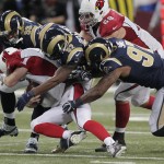 Arizona Cardinals quarterback Drew Stanton (5) is sacked by St. Louis Rams' Aaron Donald (99), Alec Ogletree (52) and Eugene Sims (97) during the second half of an NFL football game Thursday, Dec. 11, 2014 in St. Louis. (AP Photo/Tom Gannam)