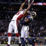 Arizona Cardinals' Michael Floyd (15) leaps to make a catch while being defended by St. Louis Rams' T.J. McDonald (25) during the first half of an NFL football game Thursday, Dec. 11, 2014 in St. Louis. The pass was incomplete. (AP Photo/Jeff Roberson)
