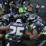 The Seattle Seahawks "Legion of Boom" defensive players including strong safety DeShawn Shead (35) huddle before taking the field for warmups before an NFL football game against the Arizona Cardinals, Sunday, Nov. 23, 2014, in Seattle. (AP Photo/Elaine Thompson)
