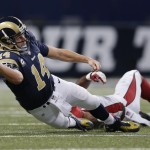St. Louis Rams quarterback Shaun Hill (14) throws an incomplete pass as he is tackled by Arizona Cardinals outside linebacker Alex Okafor (57) during the first half of an NFL football game Thursday, Dec. 11, 2014 in St. Louis. (AP Photo/Jeff Roberson)