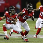 Atlanta Falcons free safety Dwight Lowery (20) runs after making an interception against the Arizona Cardinals during the first half of an NFL football game, Sunday, Nov. 30, 2014, in Atlanta. Atlanta Falcons Prince Shembo (53) William Moore (25) look on. (AP Photo/John Bazemore)