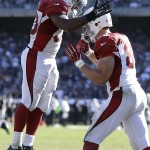 Arizona Cardinals running back Stepfan Taylor, left, celebrates with tight end John Carlson after running for a 4-yard touchdown against the Oakland Raiders during the third quarter of an NFL football game in Oakland, Calif., Sunday, Oct. 19, 2014. (AP Photo/Ben Margot)