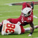 Arizona Cardinals running back Stepfan Taylor (30) is tripped up by Kansas City Chiefs strong safety Ron Parker (38) during the first half of an NFL football game, Sunday, Dec. 7, 2014, in Glendale, Ariz. (AP Photo/Matt York)