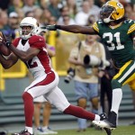 Arizona Cardinals' Andre Roberts (12) catches a touchdown pass in front of Green Bay Packers' Davon House (31) during the first half of a preseason NFL football game Friday, Aug. 9, 2013, in Green Bay, Wis. (AP Photo/Mike Roemer)