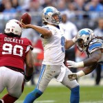 Detroit Lions quarterback Matthew Stafford (9) throws under pressure from Arizona Cardinals defensive end Darnell Dockett (90) during the first half of an NFL football game on Sunday, Dec. 16, 2012, in Glendale, Ariz. (AP Photo/Paul Connors)