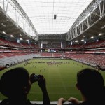 Fans watch the Arizona Cardinals during NFL football training camp practice inside University of Phoenix Stadium on Tuesday, July 30, 2013, in Glendale, Ariz. (AP Photo/Ross D. Franklin)