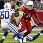 Arizona Cardinals wide receiver Larry Fitzgerald (11) gains yards after the catch as Indianapolis Colts free safety Darius Butler, rear, and Jerrell Freeman (50) defend during the first half of an NFL football game, Sunday, Nov. 24, 2013, in Glendale, Ariz. (AP Photo/Rick Scuteri)
