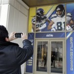 Football fan Raul Moreno of Jersey City, N.J., stops to take a picture of the entrance to the Seattle Seahawks team hotel Monday, Jan. 27, 2014, in Jersey City, N.J. Moreno says he will be rooting for the Denver Broncos when they play the Seattle Seahawks in the Super Bowl XLVIII football game. (AP Photo/Jeff Roberson)