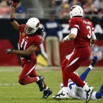 Arizona Cardinals wide receiver Larry Fitzgerald (11) throws the football against the Indianapolis Colts as quarterback Carson Palmer (3) blocks during the first half of an NFL football game, Sunday, Nov. 24, 2013, in Glendale, Ariz. (AP Photo/Rick Scuteri)