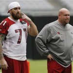 Arizona Cardinals' Daryn Colledge (71) talks with general manager Steve Keim at NFL football training camp practice on Monday, Aug. 5, 2013, in Glendale, Ariz. (AP Photo/Ross D. Franklin)