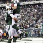 New York Jets quarterback Greg McElroy (14) is lifted by teammate Konrad Reuland after throwing a 1-yard touchdown pass to tight end Jeff Cumberland during the second half of an NFL football game against the Arizona Cardinals, Sunday, Dec. 2, 2012, in East Rutherford, N.J. (AP Photo/Kathy Willens)