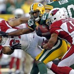 Green Bay Packers' Johnathan Franklin (23) stiff arms Arizona Cardinals' Lorenzo Alexander (97) on a punt return during the first half of a preseason NFL football game Friday, Aug. 9, 2013, in Green Bay, Wis. (AP Photo/Mike Roemer)