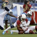 Arizona Cardinals wide receiver Larry Fitzgerald (11) can't hang onto a pass as he is defended by Tennessee Titans cornerback Jason McCourty (30) and safety Bernard Pollard (31) in the second quarter of an NFL football game Sunday, Dec. 15, 2013, in Nashville, Tenn. (AP Photo/Mark Zaleski)