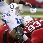 Indianapolis Colts' Andrew Luck (12) looks down the field as he is brought down by Arizona Cardinals' Calais Campbell (93) and Darnell Dockett, as Luck throws an interception on the play, during the first half of an NFL football game Sunday, Nov. 24, 2013, in Glendale, Ariz. (AP Photo/Ross D. Franklin)