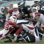 Philadelphia Eagles' Nick Foles, center, is tackled by Arizona Cardinals' Marcus Benard, left, and Daryl Washington during the second half of an NFL football game, Sunday, Dec. 1, 2013, in Philadelphia. (AP Photo/Tim Donnelly)