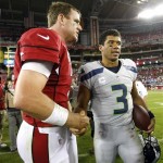 Arizona Cardinals quarterback Carson Palmer, left, and Seattle Seahawks quarterback Russell Wilson greet each other during after an NFL football game, Thursday, Oct. 17, 2013, in Glendale, Ariz. The Seahawks won 34-22. (AP Photo/Rick Scuteri)