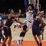 New York Knicks' Carmelo Anthony (7) drives past Phoenix Suns' Gerald Green (14) and Channing Frye (8) during the first half of an NBA basketball game, Monday, Jan. 13, 2014, in New York. (AP Photo/Frank Franklin II)