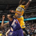 Denver Nuggets forward J.J. Hickson, right, goes up for a shot over Phoenix Suns forward Markieff Morris in the fourth quarter of the Suns' 103-99 victory in an NBA basketball game in Denver on Friday, Dec. 20, 2013. (AP Photo/David Zalubowski)