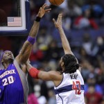 Washington Wizards center Nene (42), of Brazil, goes to the basket against Phoenix Suns center Jermaine O'Neal (20) during the first half of an NBA basketball game on Saturday, March 16, 2013, in Washington. (AP Photo/Nick Wass)
