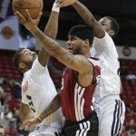Miami Heat guard D.J. Kennedy, center, splits the defense of Phoenix Suns' Markieff Morris, left, and Archie Goodwin in the third quarter of an NBA Summer League basketball game, Sunday, July 21, 2013, in Las Vegas. (AP Photo/Julie Jacobson)