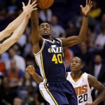 Utah Jazz forward Jeremy Evans (4) pulls down a long rebound as Phoenix Suns guard Archie Goodwin (20) looks on during the first half of an NBA basketball game on Saturday, Nov. 30, 2013, in Phoenix. (AP Photo/Matt York)