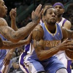 
Denver Nuggets' Andre Iguodala tries to drive against Phoenix Suns' Michel Beasley, left, and Jared Dudley, right, during the first half of an NBA basketball game, Monday, March 11, 2013, in Phoenix. (AP Photo/Matt York)