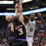 Boston Celtics forward Jeff Green, right, passes the ball off as he is double-teamed by Phoenix Suns center Marcin Gortat, left, of Poland, and Jared Dudley, center, in the first half of an NBA basketball game Friday, Feb. 22, 2013, in Phoenix. The Celtics won 113-88.(AP Photo/Paul Connors)
