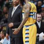 Denver Nuggets head coach Brian Shaw, back, talks with forward Wilson Chandler as he prepares to put the ball back into play against the Phoenix Suns in the first quarter of an NBA basketball game in Denver on Friday, Dec. 20, 2013. (AP Photo/David Zalubowski)