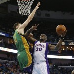 Phoenix Suns center Jermaine O'Neal (20) drives to the basket around New Orleans Hornets power forward Jason Smith (14) in the first half of an NBA basketball game in New Orleans, Wednesday, Feb. 6, 2013. (AP Photo/Bill Haber)