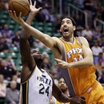 
Phoenix Suns' Luis Scola (14), of Argentina, lays the ball up as Utah Jazz's Paul Millsap (24) defends in the first quarter during an NBA basketball game, Wednesday, March 27, 2013, in Salt Lake City. (AP Photo/Rick Bowmer)