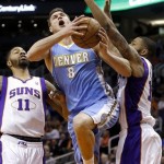 Denver Nuggets' Danilo Gallinari (8), of Italy, drives between Phoenix Suns' Markieff Morris (11) and Marcus Morris, right, during the first half of an NBA basketball game, Monday, March 11, 2013, in Phoenix. (AP Photo/Matt York)