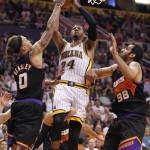 Indiana Pacers forward Paul George, center, attempts a field goal between Phoenix Suns forward Michael Beasley, left, and Hamed Haddadi, right, of Iran, during the first half of an NBA basketball game, Saturday, March 30, 21013, in Phoenix. (AP Photo/Paul Connors)