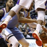 Denver Nuggets' Andre Iguodala chases a loose ball as Phoenix Suns' Markieff Morris, left, and P.J. Tucker defend during the first half of an NBA basketball game, Monday, March 11, 2013, in Phoenix. (AP Photo/Matt York)
