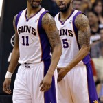 Phoenix Suns' Markieff Morris, right, and his twin brother, Marcus Morris (11) wait for play to start against the Houston Rockets' during the second half of an NBA basketball game, Monday, April 15, 2013, in Phoenix. (AP Photo/Matt York)