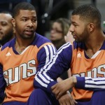 Phoenix Suns forwards Marcus Morris, left, and his twin brother Markieff talk on bench as the Suns played the Denver Nuggets in the first quarter of an NBA basketball game in Denver on Tuesday, Feb. 18, 2014. (AP Photo/David Zalubowski)
