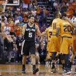 San Antonio Spurs' Patty Mills (8), of Australia, and Cory Joseph (5) walk back to the team bench as Phoenix Suns' Marcus Morris (15), Archie Goodwin (20), Markieff Morris (11) and Ish Smith (3) celebrate a score by Goodwin during the second half of an NBA basketball game, Friday, Feb. 21, 2014, in Phoenix. The Suns defeated the Spurs 106-85. (AP Photo/Ross D. Franklin)