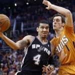 San Antonio Spurs' Danny Green (4) tries to drive past Phoenix Suns' Goran Dragic (1), of Slovenia, during the second half of an NBA basketball game, Friday, Feb. 21, 2014, in Phoenix. The Suns defeated the Spurs 106-85. (AP Photo/Ross D. Franklin)